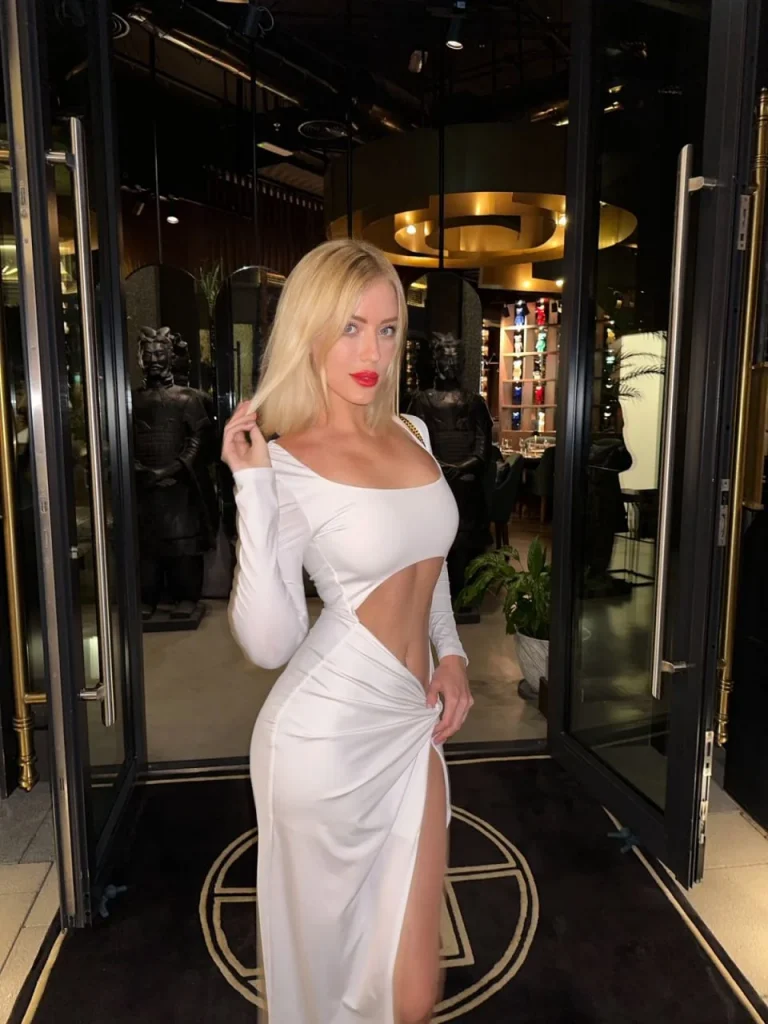 Veronica in a white tight dress on a museum visit